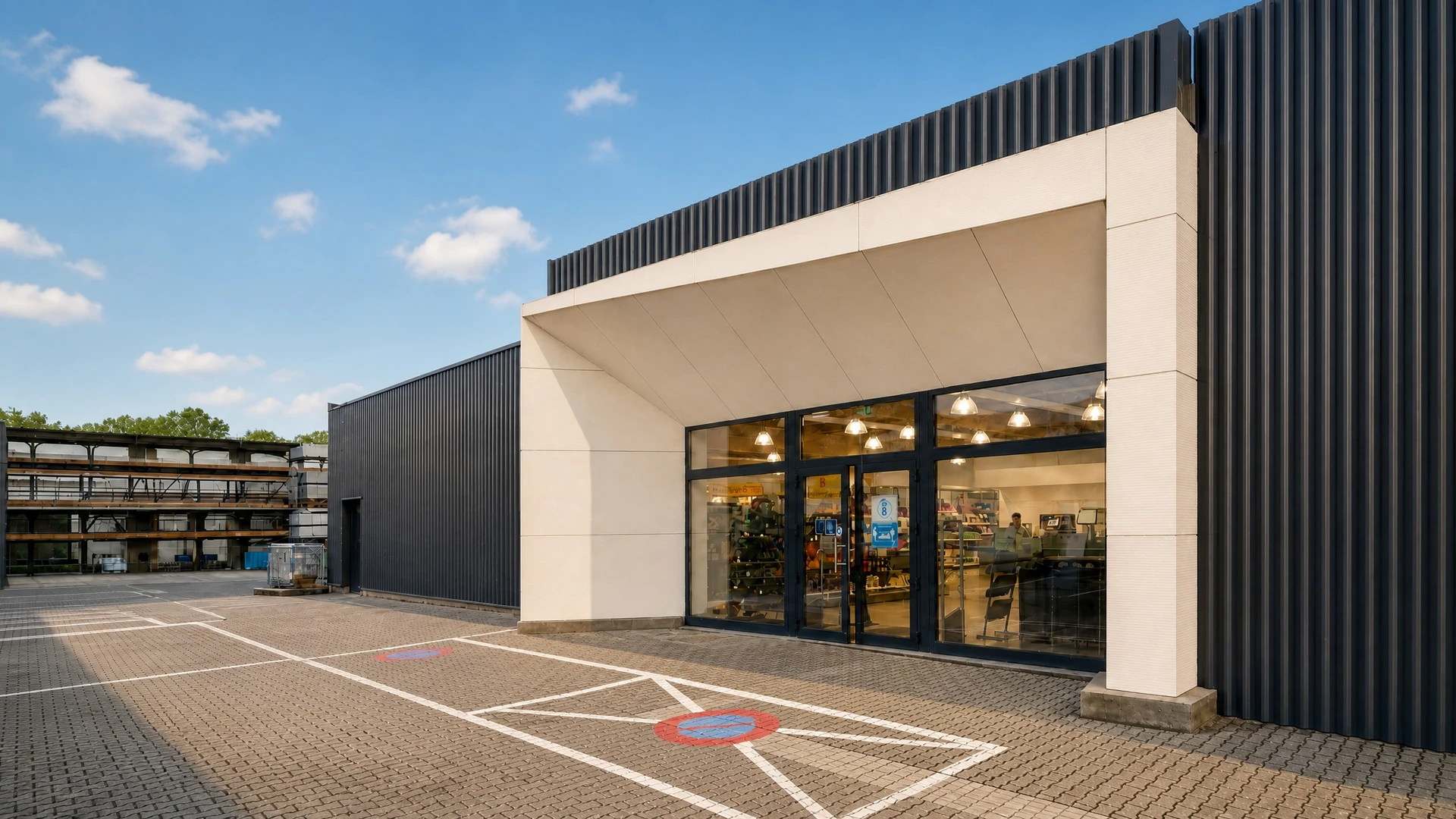 Entrée d'un commerce de détail, façade extérieure moderne avec bardage métallique noir et panneaux blancs