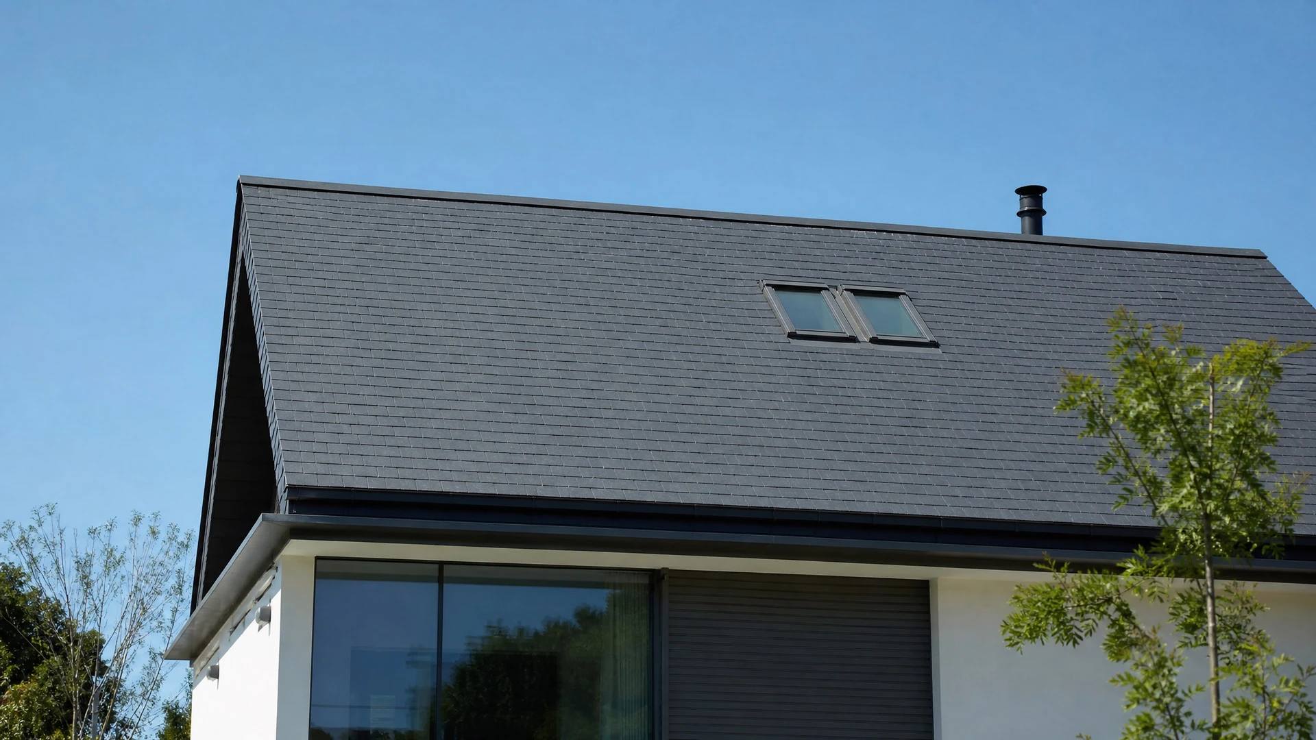 Extérieur d'une maison avec toiture métallique grise à joints debout et lucarne ouverte
